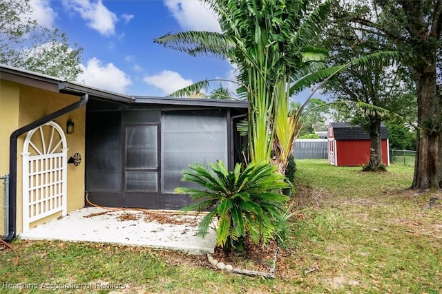 view of side of home with a lawn and a storage unit