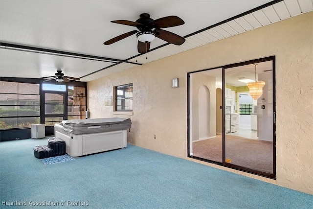 unfurnished living room featuring carpet and ceiling fan with notable chandelier