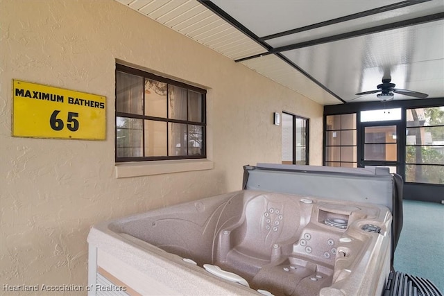 view of patio / terrace with ceiling fan and a hot tub