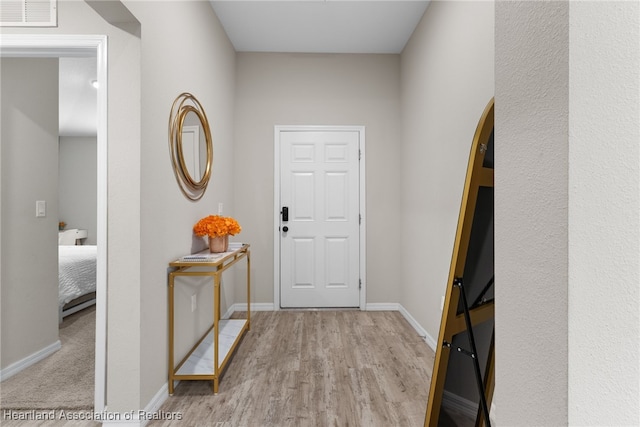 entryway featuring baseboards, visible vents, and wood finished floors