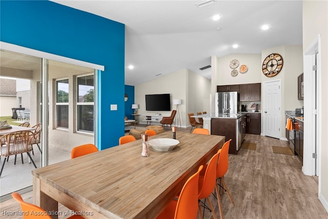 dining space with visible vents, vaulted ceiling, wood finished floors, and recessed lighting