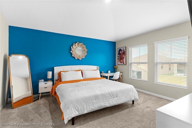 bedroom with an accent wall, carpet floors, and baseboards