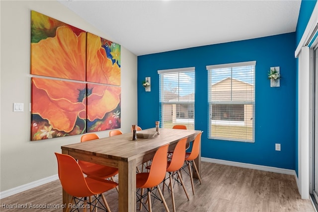 dining space featuring baseboards and wood finished floors