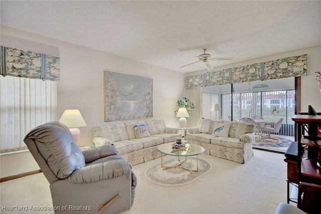 carpeted living room featuring ceiling fan and a textured ceiling