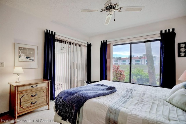 bedroom featuring ceiling fan, light colored carpet, and a textured ceiling