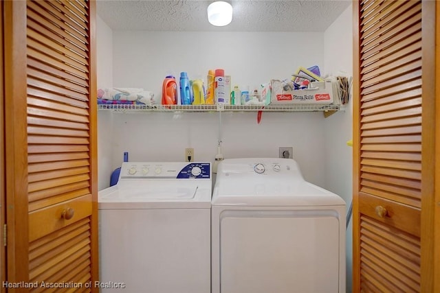 clothes washing area featuring washer and clothes dryer and a textured ceiling