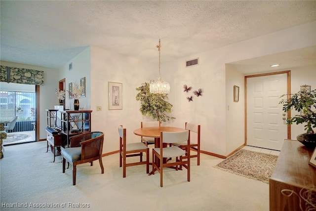 carpeted dining area featuring a textured ceiling