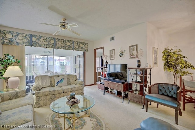 carpeted living room with a textured ceiling and ceiling fan