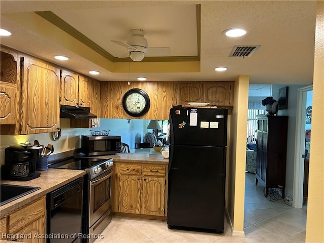 6000 Matanzas Dr, Sebring, FL 33872 - kitchen with black appliances, under cabinet range hood, a ceiling fan, a tray ceiling, and brown cabinetry