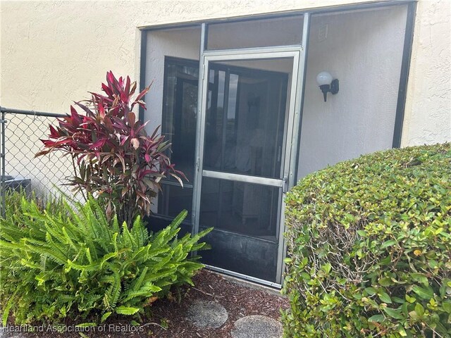 6000 Matanzas Dr, Sebring, FL 33872 - doorway to property with stucco siding and fence