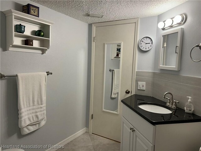 6000 Matanzas Dr, Sebring, FL 33872 - bathroom with a textured ceiling, vanity, tile patterned flooring, and backsplash