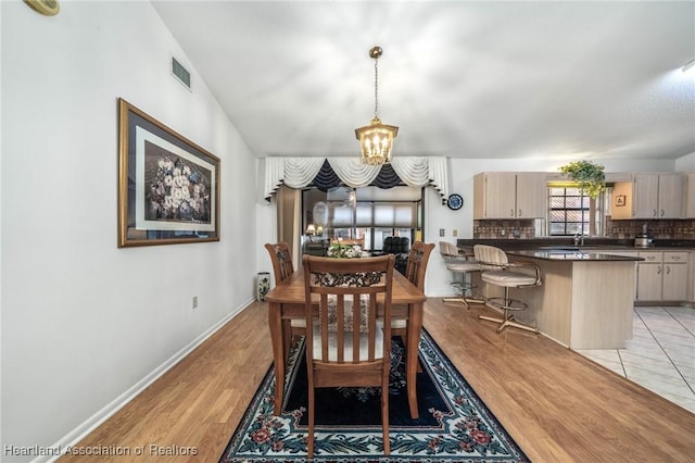 dining room featuring a notable chandelier, light hardwood / wood-style floors, and sink