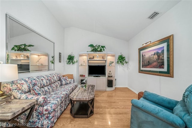 living room featuring light hardwood / wood-style floors and lofted ceiling