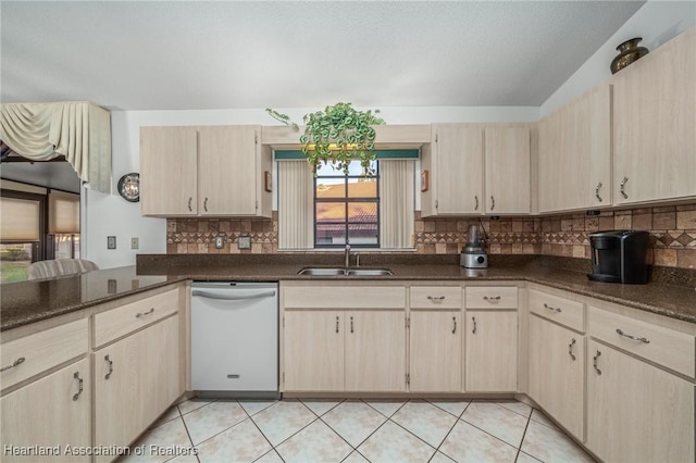 kitchen with sink, vaulted ceiling, dishwasher, tasteful backsplash, and light brown cabinetry