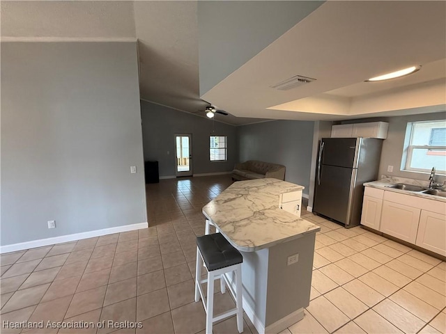 4329 Elson Ave, Sebring, FL 33875 - kitchen with freestanding refrigerator, a sink, light tile patterned floors, plenty of natural light, and vaulted ceiling