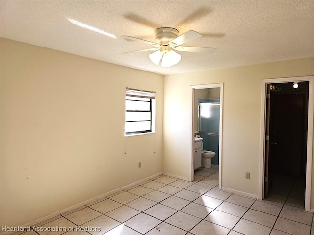 unfurnished bedroom featuring light tile patterned floors, a textured ceiling, ensuite bathroom, and ceiling fan