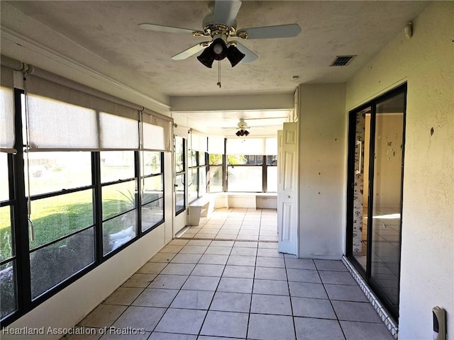 unfurnished sunroom with ceiling fan