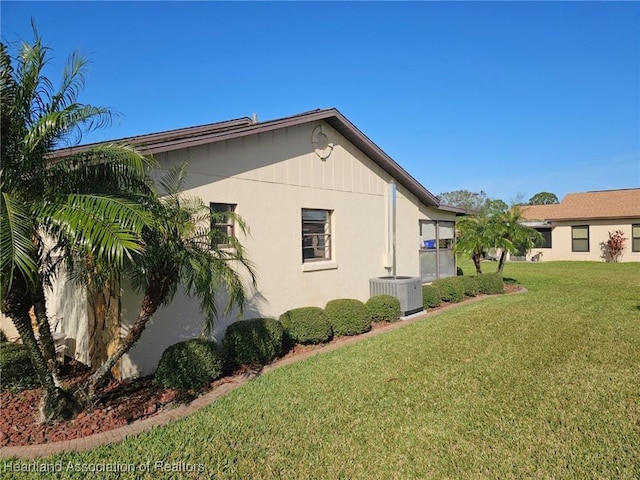 view of property exterior with a yard and central air condition unit