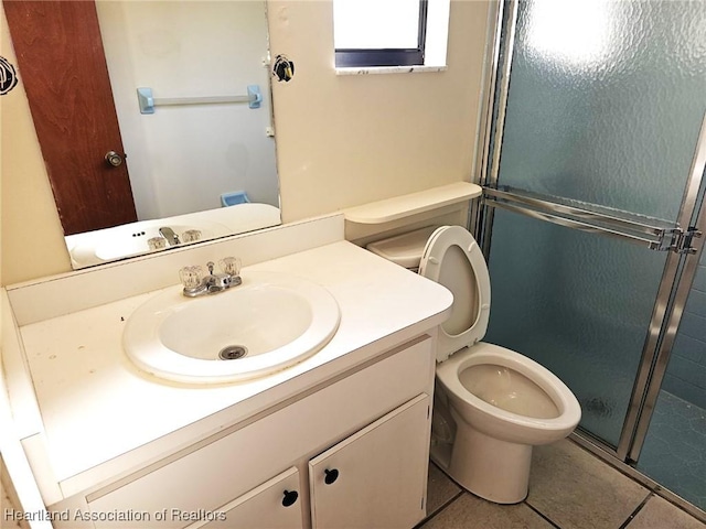 bathroom featuring tile patterned flooring, vanity, toilet, and a shower with shower door