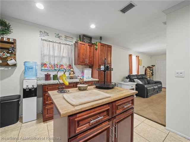 kitchen featuring a center island, ornamental molding, and light tile patterned flooring