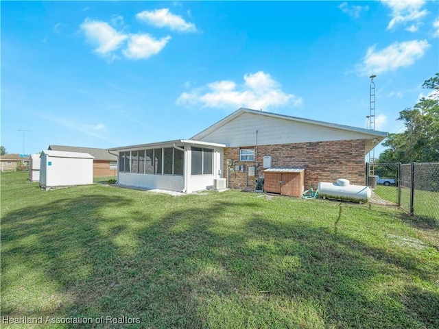 back of property with a sunroom and a yard