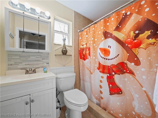 bathroom with tasteful backsplash, vanity, walk in shower, and toilet