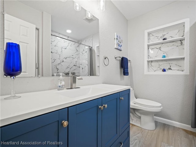 bathroom with hardwood / wood-style flooring, vanity, toilet, and curtained shower