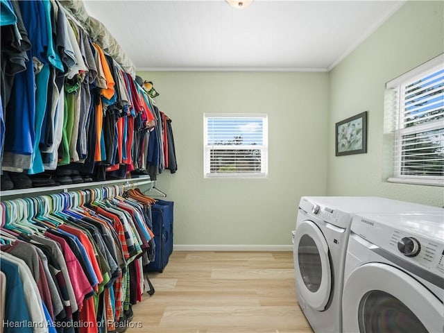 laundry area with separate washer and dryer, ornamental molding, and light hardwood / wood-style floors