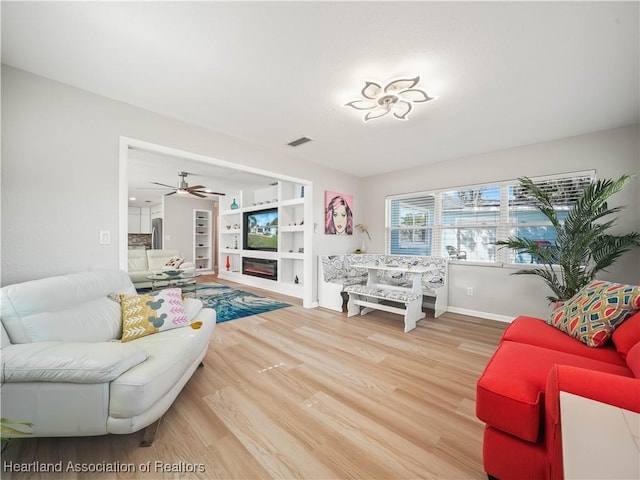 living room with wood-type flooring and built in shelves