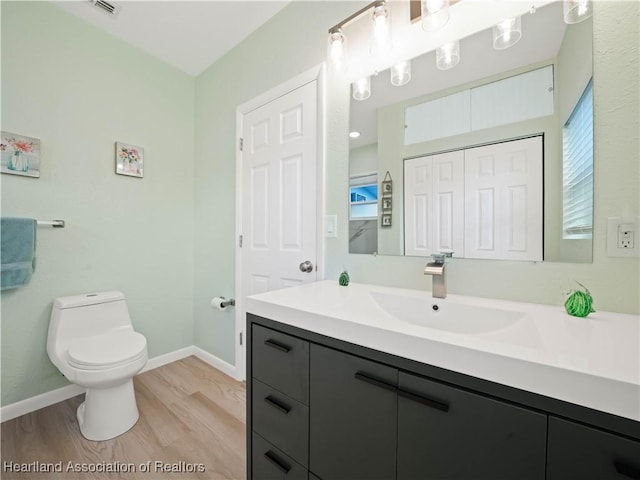 bathroom featuring vanity, hardwood / wood-style floors, and toilet