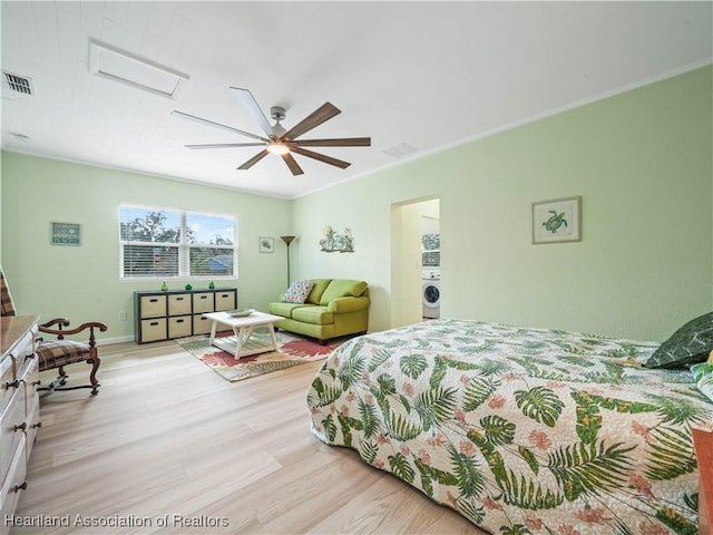 bedroom with ceiling fan, ornamental molding, washer / clothes dryer, and light hardwood / wood-style floors