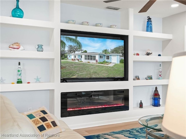 room details featuring built in shelves, ceiling fan, and wood-type flooring