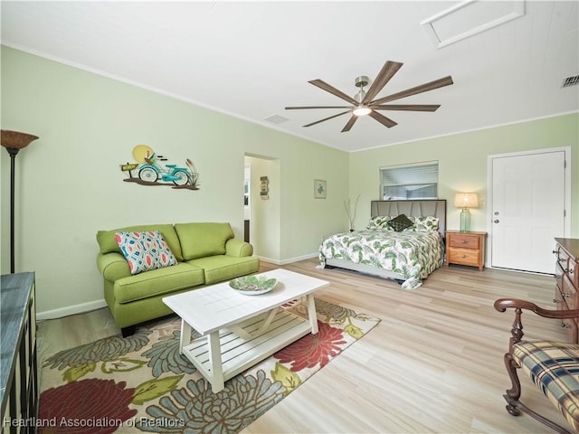 bedroom featuring ceiling fan, crown molding, and light hardwood / wood-style floors