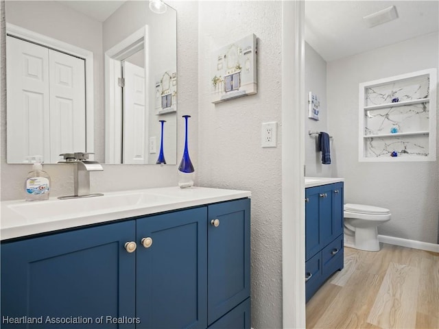 bathroom with vanity, wood-type flooring, and toilet