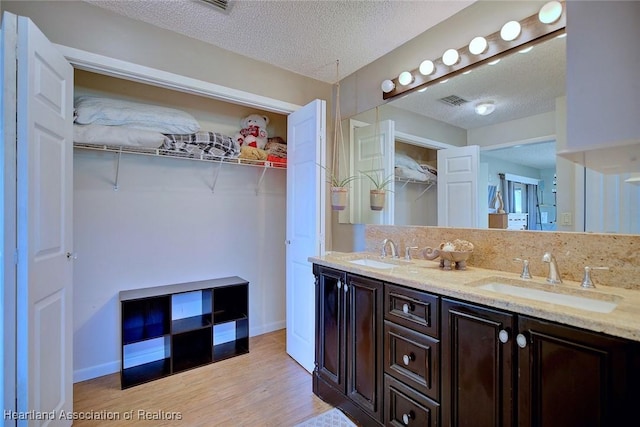 bathroom featuring vanity, wood-type flooring, and a textured ceiling