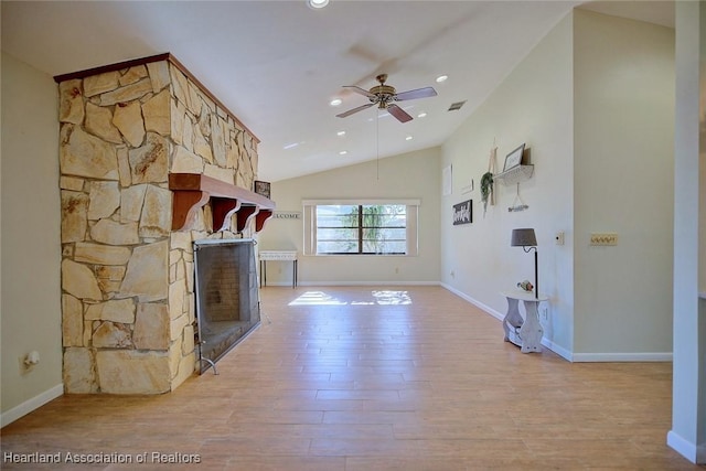 unfurnished living room featuring a stone fireplace, ceiling fan, lofted ceiling, and light wood-type flooring