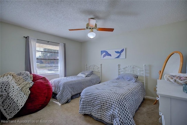 carpeted bedroom featuring ceiling fan and a textured ceiling