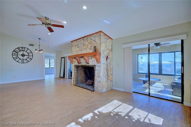 unfurnished living room featuring ceiling fan, a fireplace, lofted ceiling, and hardwood / wood-style flooring