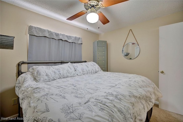 carpeted bedroom featuring ceiling fan and a textured ceiling