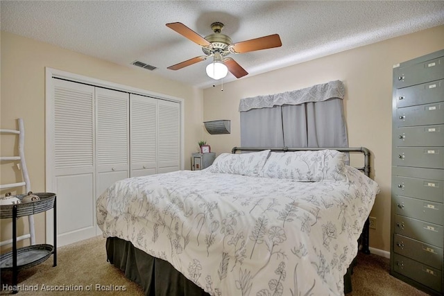 bedroom with carpet flooring, ceiling fan, a closet, and a textured ceiling