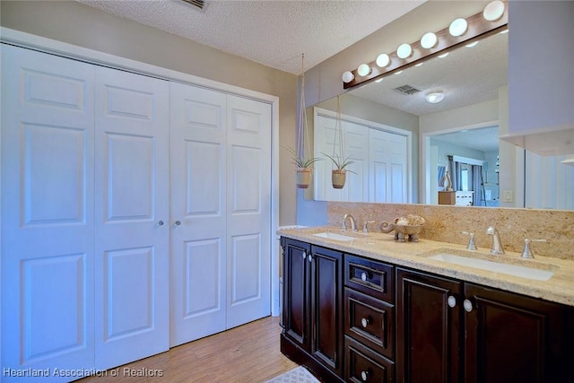 bathroom with vanity, a textured ceiling, and hardwood / wood-style flooring