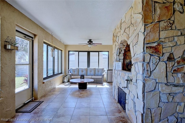 unfurnished living room featuring light tile patterned floors and ceiling fan