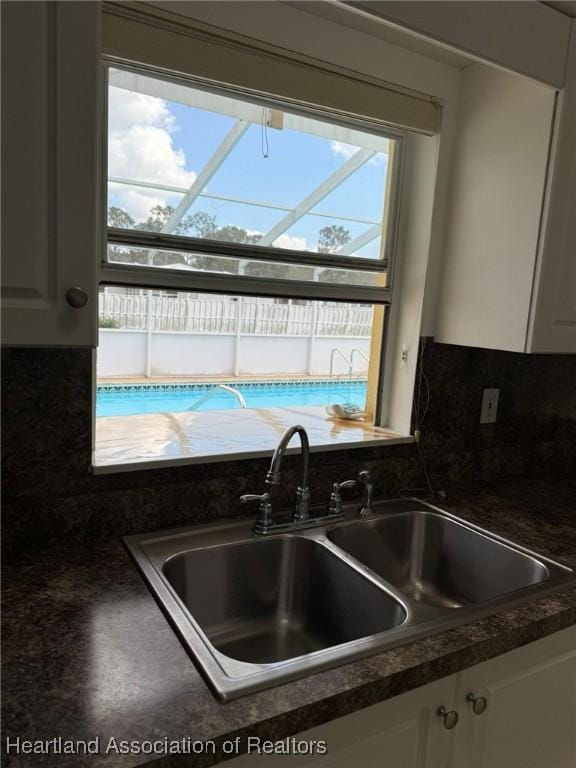 kitchen with sink, white cabinets, and decorative backsplash