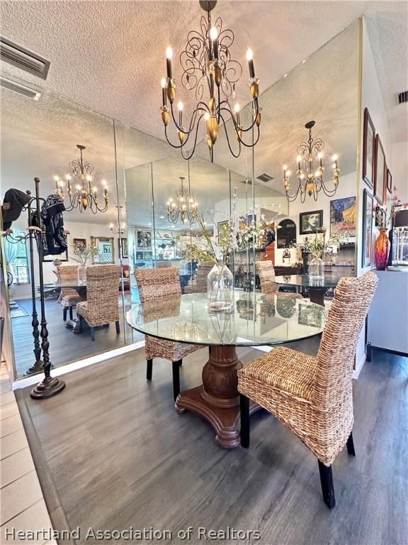 dining space with hardwood / wood-style flooring, a textured ceiling, and vaulted ceiling