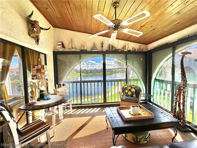 sunroom / solarium with a water view, ceiling fan, and wood ceiling