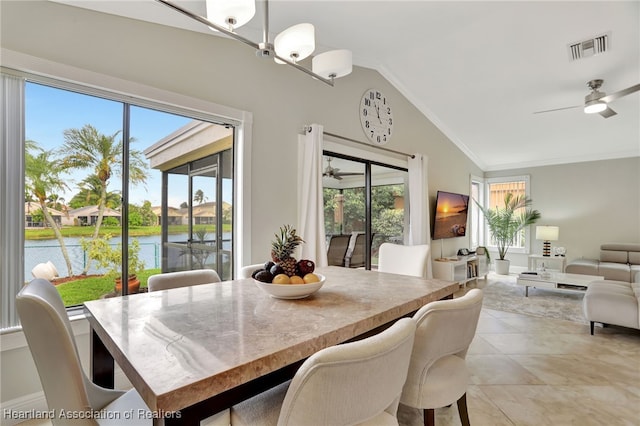 tiled dining room featuring ceiling fan, a water view, lofted ceiling, and a wealth of natural light