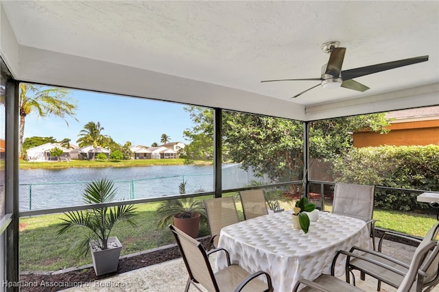 sunroom / solarium featuring a wealth of natural light, a water view, and ceiling fan