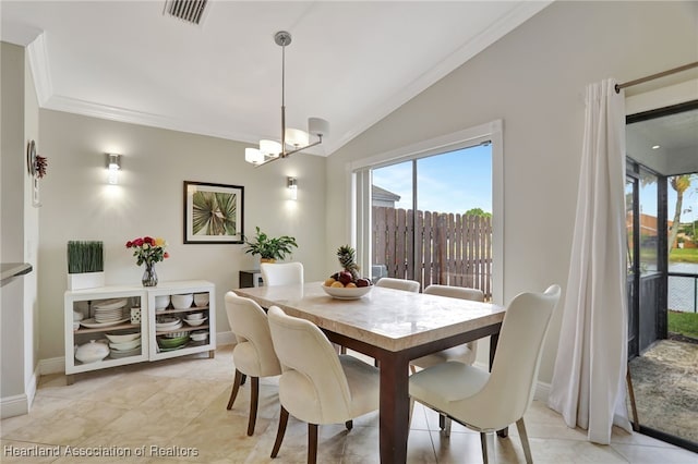 tiled dining room featuring ornamental molding, vaulted ceiling, and an inviting chandelier