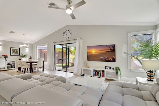 living room with ceiling fan with notable chandelier, crown molding, and vaulted ceiling