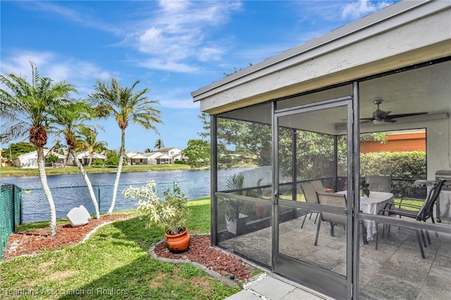 exterior space featuring ceiling fan and a water view